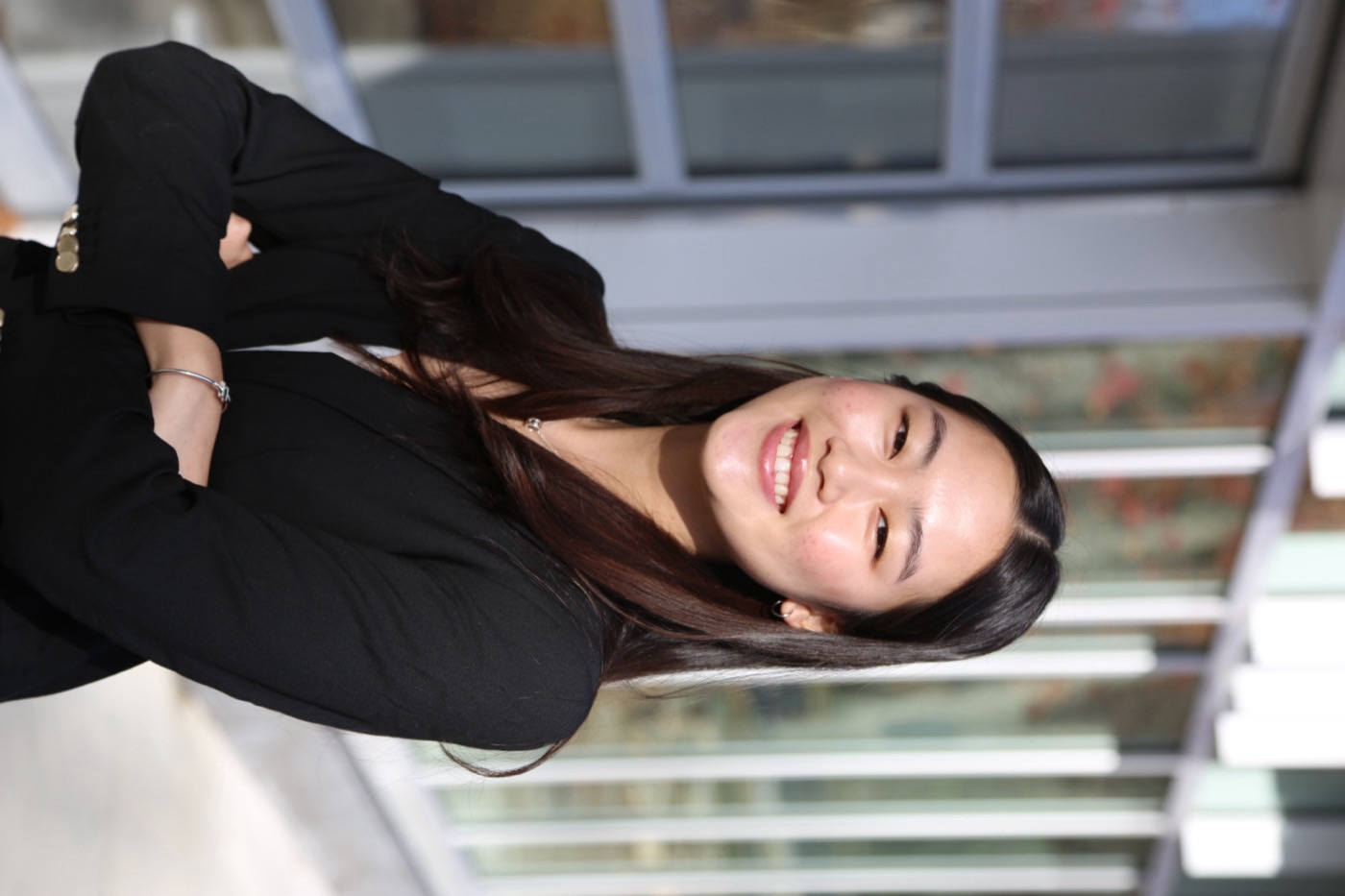 Davina Li, standing outdoors with her arms folded